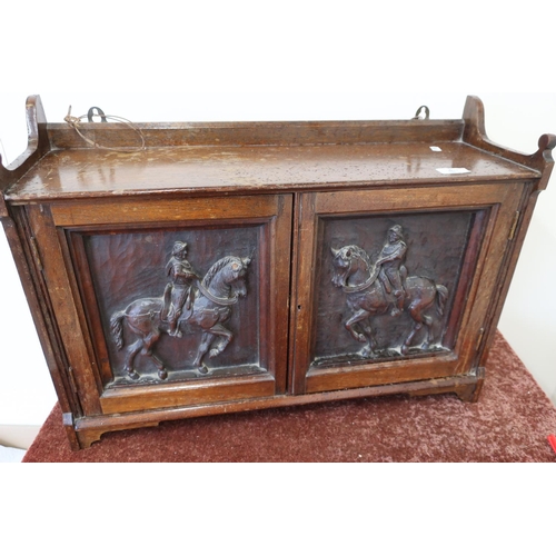 407 - Oak wall cabinet enclosed by two carved panelled doors depicting knights on horses (63cm x 20cm x 45... 