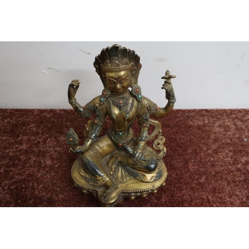 27 - Signed oriental gilt bronze figure of a seated deity, set with various hard stones and signature pan... 