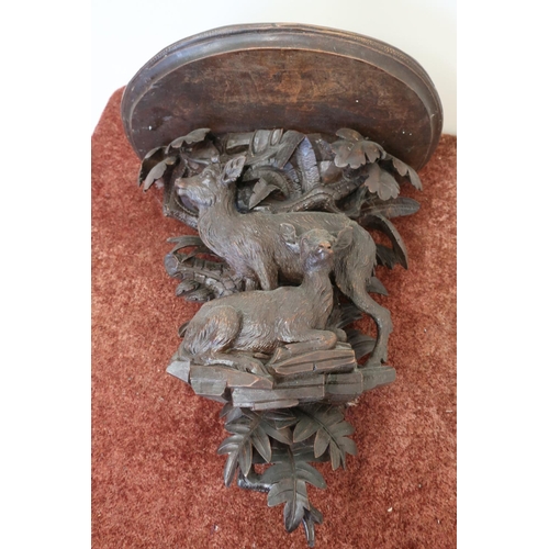 125 - 19th/20th C carved oak Black Forrest style wall bracket, the D shaped shelf supported by stag and de... 