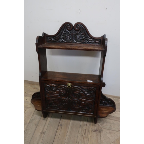 188 - Carved oak wall shelf with raised swan neck pediments above shelf and open centre, above heavily car... 