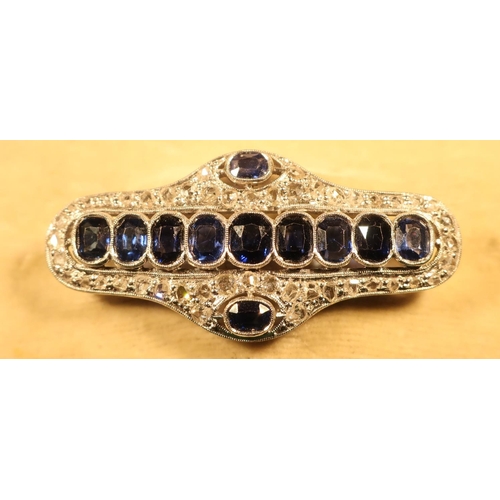 369 - White metal mounted bar brooch set with eleven sapphires and multiple diamond chips