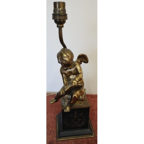 198 - Table lamp in the form of a gilt metal cherub scribing a book, on raised black slate and gilt base (... 