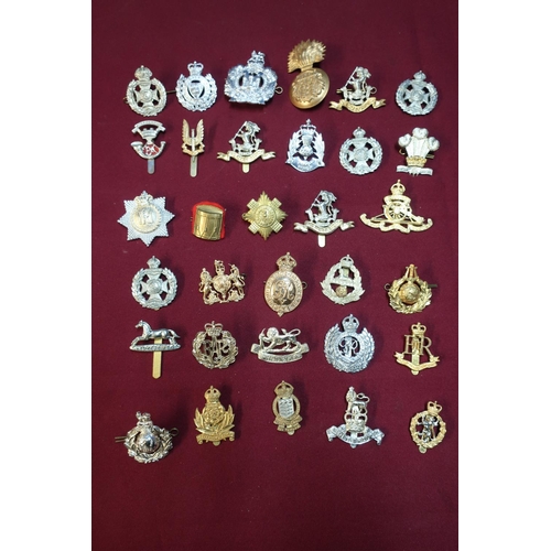 117 - Box containing approximately fifty military cap badges for various regiments including Staybright ex... 