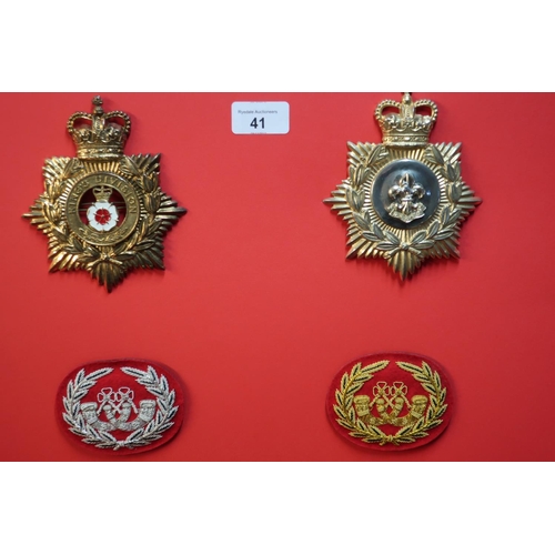 41 - Board mounted with staybright Kings Division Regiment helmet badges and two embroidered bugle badges
