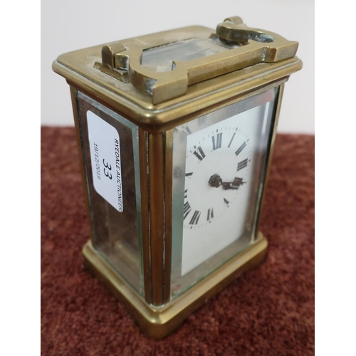 33 - Brass cased French made carriage clock with white enamel dial, complete with key and swing handle (h... 