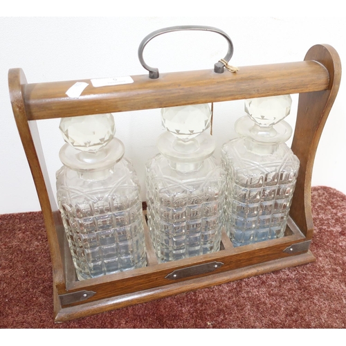 5 - Mid - late 20th C oak three sectional Tantalus, with three glass decanters