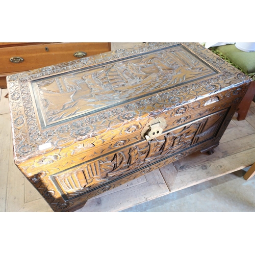 225 - Carved rectangular Camphor wood box with hinged top and oriental scenes, on lion paw supports (100cm... 