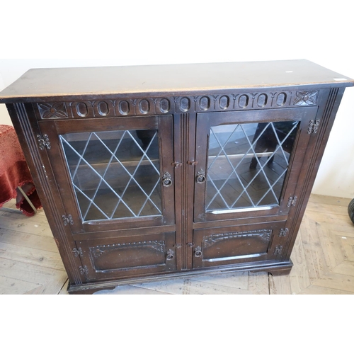 226 - Oak cabinet enclosed by two lead glazed doors above two further cupboard doors (111cm x 33cm x 99cm)