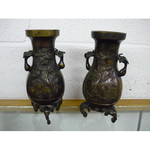 85 - Pair of Japanese bronze vases on elephant head supports, with floral panel detail to the bodies (26.... 