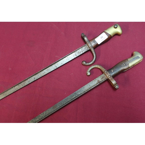 49 - Two 19th C French/Belgium tri-form bayonets, the top straps dated 1878 with brass and wood grips, th... 