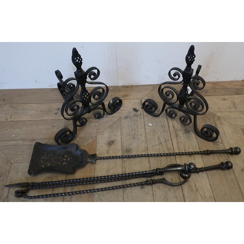 490 - Pair of wrought metal fire dogs and a three piece steel fire companion set