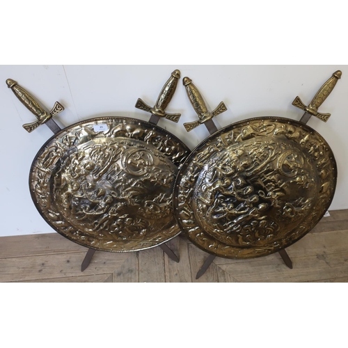 239 - Pair of decorative embossed brass shields and sword wall plaque (diameter 56cm)