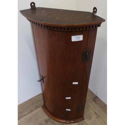 115 - Small mahogany bowfront single door wall mounted corner cabinet