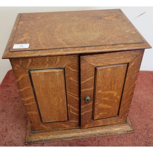24 - Edwardian oak table/smokers cabinet enclosed by two panelled cupboard doors with fitted interior, in... 