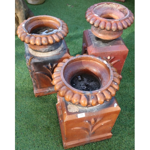 558 - Set of three Victorian earthenware glazed garden urns on square bases (height 55cm)