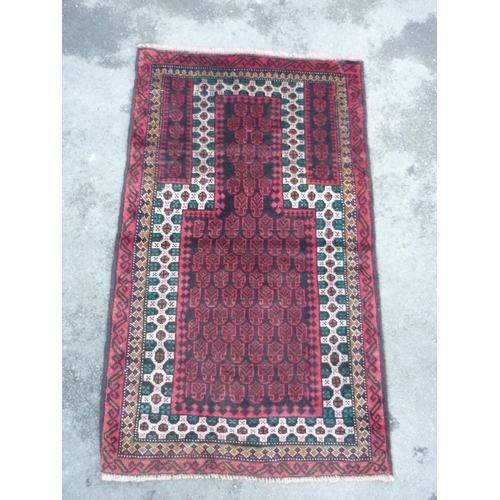 605 - Traditional pattern red ground wool rug (80cm x 137cm)