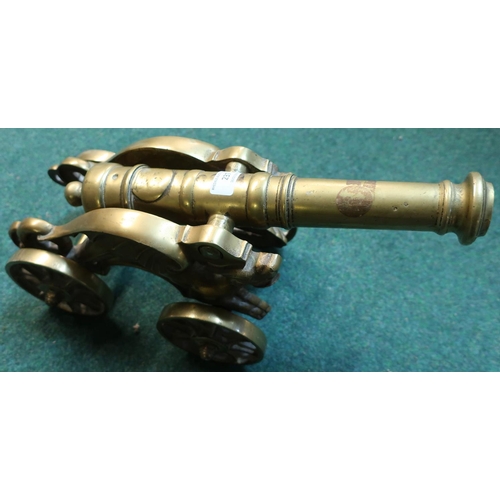 23 - Heavy cast brass model of a cannon on four wheels, barrel length 15 inches