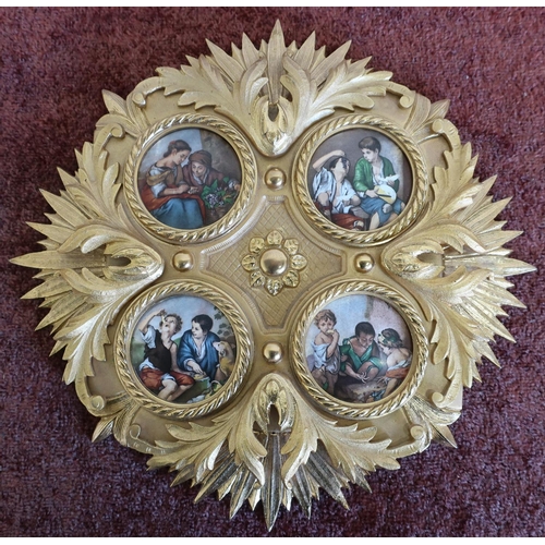 322 - Circular gilt wall plaque inset with four porcelain panels depicting various figures (diameter 28cm)