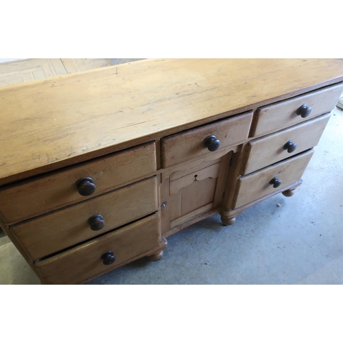 322 - Victorian pine sideboard with central drawer above recessed cupboard door flanked by six further sho... 