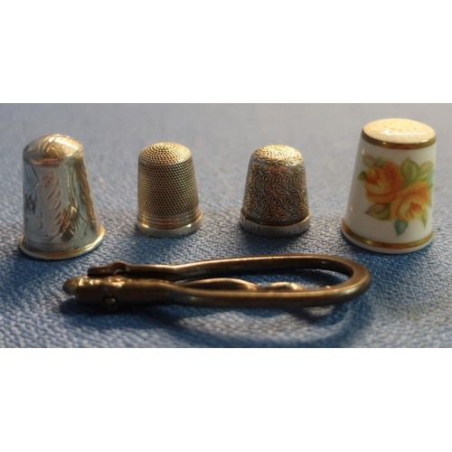 62 - Three silver hallmarked thimbles, a folding button hook and a Royal Worcester thimble (5)