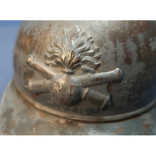 63 - WWI French artillery steel helmet with traces of painted detail complete with leather liner.