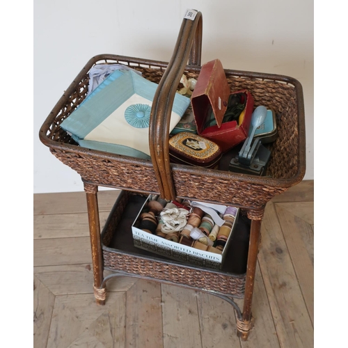 269 - Early to mid 20th C bamboo and wicker work two tier sewing type table with various accessories, tins... 