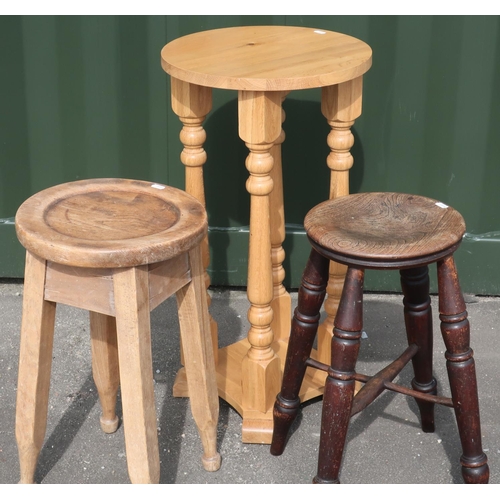 72 - Two country style four legged stools and a light oak jardiniere stand on four turned wood supports (... 