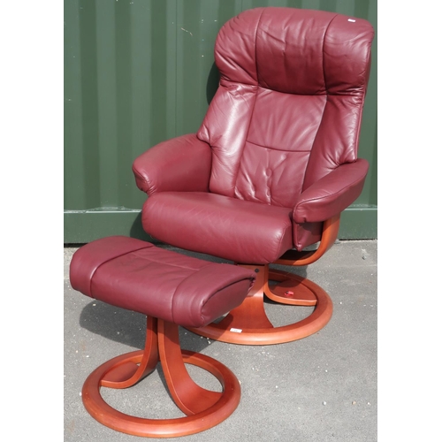 73 - Revolving reclining leather armchair with associated footstool