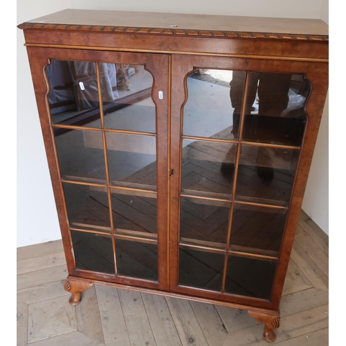 281 - Walnut bookcase enclosed by two glazed cupboard doors (91cm x 31cm x 121cm)