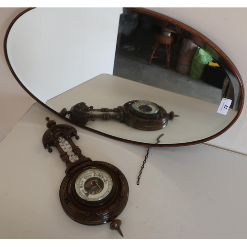 39 - Oval oak framed bevelled edge wall mirror and a carved oak framed wall barometer (2)