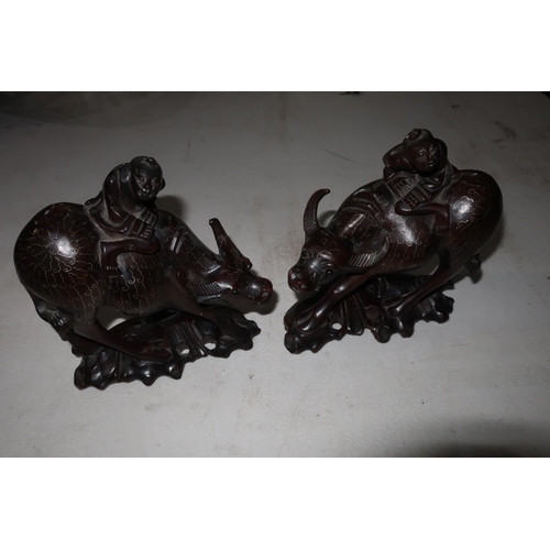 325 - Pair of Chinese carved hardwood figures riding water buffalo with inlaid white metal detail and inse... 