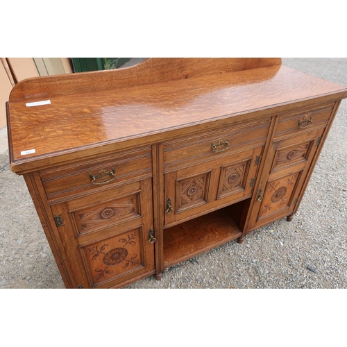 157 - Medium oak sideboard with raised back above central drawer, paneled cupboard door, and open base fla... 