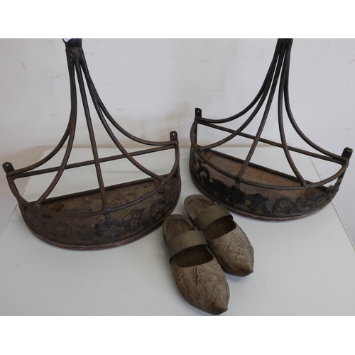 381 - Pair of wrought metal D shaped wall shelves with wooden tops and a pair of carved wood clogs