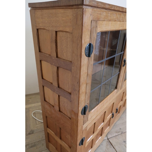 141 - Yorkshire oak craftsman made Mouseman style side cabinet with two lead glazed doors and two glass sh... 