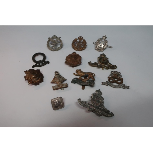 59 - Selection of various assorted British military cap badges including naval, Royal Artillery, AAC, etc