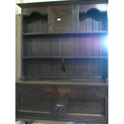 115 - 20th C oak dresser, twin shelf planked back with cupboard, the base with two paneled doors on cabrio... 