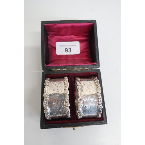 93 - Pair of Edwardian hallmarked silver oval napkin rings, with cast borders and engraved detail, Birmin... 