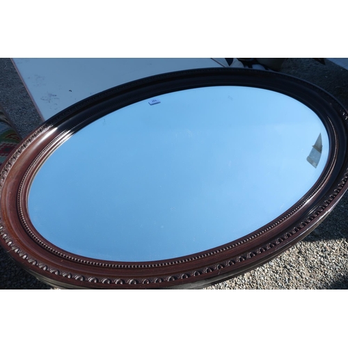 131 - Large bevelled edge mahogany framed oval wall mirror (69.5cm x 100cm)