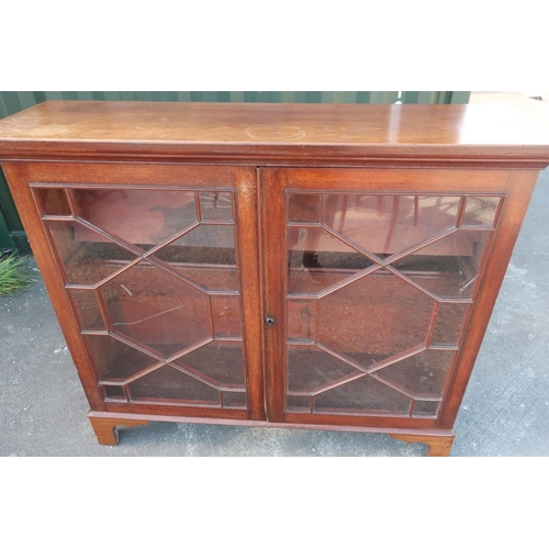139 - Mahogany three tier bookcase enclosed by glassed doors (cracked), on raised bracket supports (123cm ... 