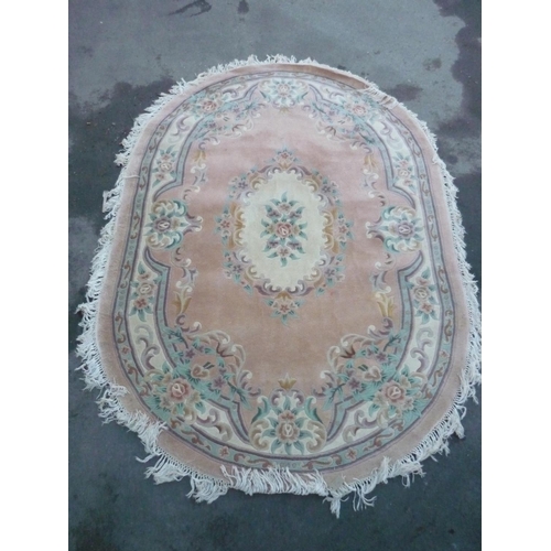 399 - Oval Chinese embossed washed woollen rug, pink ground with central floral medallion and floral patte... 