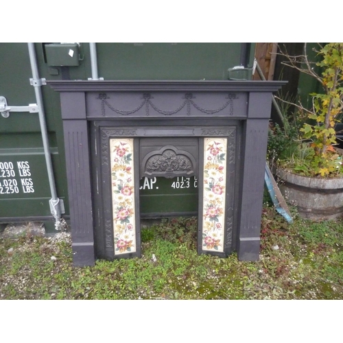 258 - Wood fire surround decorated with swags, and a cast fireplace with flower design and tiles