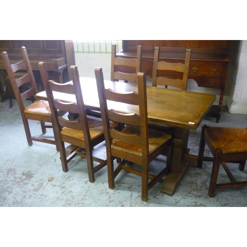 244 - Oak dining table with trestle ends and a set of six ladder back rush seated chairs