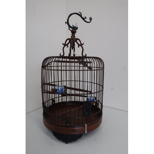 79 - Chinese carved wood and wirework cylindrical birdcage, with three perches, on metal dragon hanging h... 