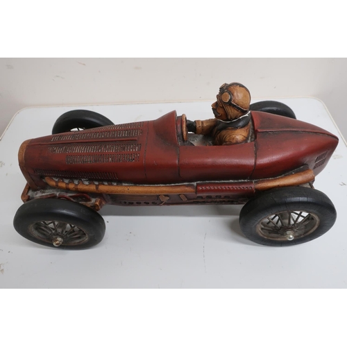 12 - Cast resin model of a vintage single seater racing car with red body on black spoked wheels (L50cm)
