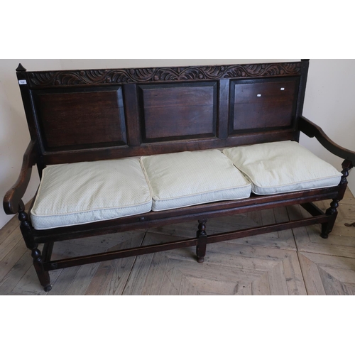 426 - Geo. III oak settle, three panel back with carved cresting rail and solid seat, on turned supports w... 