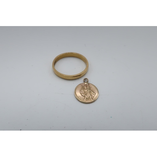 20 - 22ct gold hallmarked wedding band, 3.6g and a 9ct gold hallmarked St. Christopher charm, 4.6g gross ... 