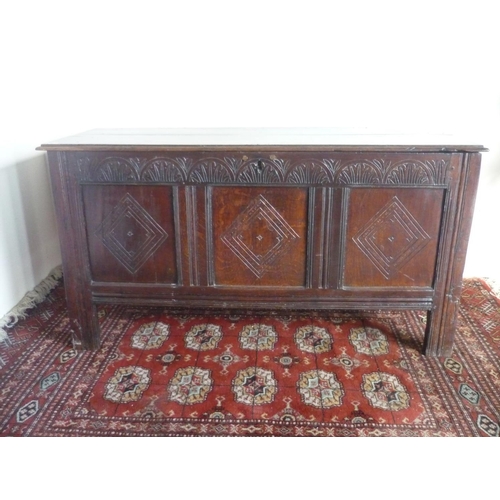 80 - 18th century oak coffer, hinged planked top above  arched carved frieze and three lozenged panelled ... 