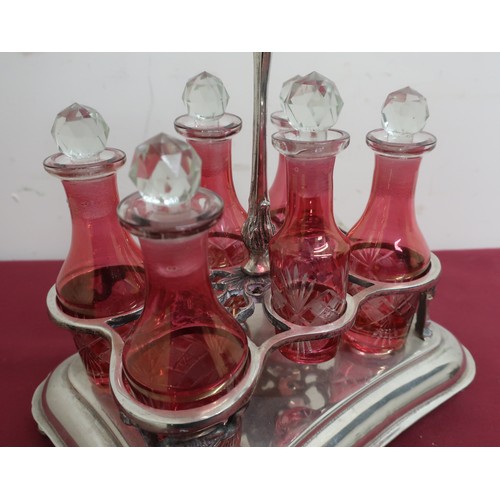 83 - Continental silver plated shaped rectangular six bottle cruet, with six red overlay cut bottles, bra... 