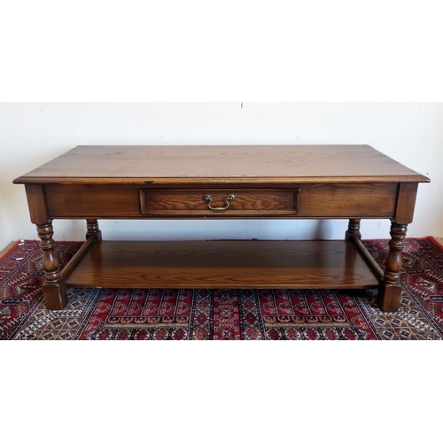 77 - Reprodux oak rectangular coffee table with moulded top and frieze drawer on baluster supports joined... 