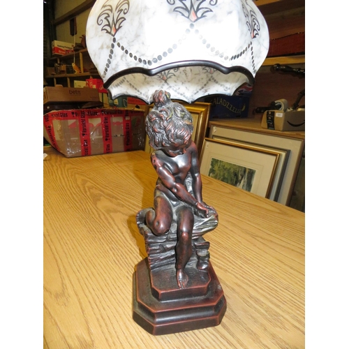 382 - Resin table lamp in the form of a child sitting on a rock,  with 1930's style shade